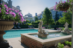 Troy apartment for rent - Outdoor pool with fountain sculptures and landscaping at Regents Club of Troy Apartments, Troy, MI 48084