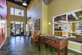 Royal Oak apartment for rent - a game room with a foosball table and a chair at Village Club of Royal Oak, Royal Oak, MI 48067