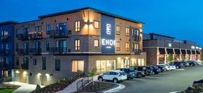 Duluth apartment for rent - The image shows a building with the word "END" on it, with cars parked in front and a clear sky in the background.