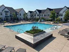 Grand Rapids apartment for rent - A large swimming pool surrounded by lounge chairs and a wooden deck.