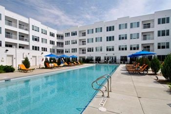 A swimming pool with a white building in the background