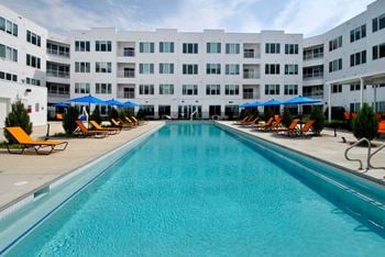 A large swimming pool with a white building in the background