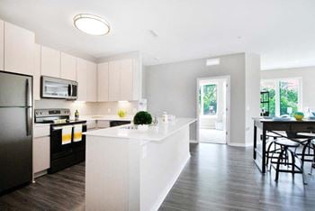 A kitchen with a large white island next to a doorway