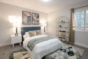 St. Louis apartment for rent - A bedroom with a large bed and a shelf with shoes on it.