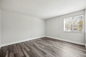 Florissant apartment for rent - A room with wooden flooring and a window showing trees outside.