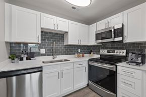 Indianapolis apartment for rent - A kitchen with white cabinets and a black stove top oven.