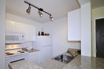 Southgate apartment for rent - A kitchen with white cabinets and granite countertops.