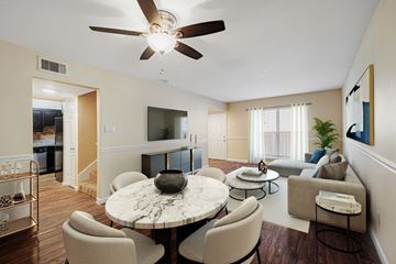 Houston apartment for rent - A living room with a white ceiling fan and a round marble table surrounded by chairs.