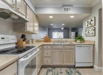 Oklahoma City apartment for rent - A kitchen with a white stove top oven and a white dishwasher.