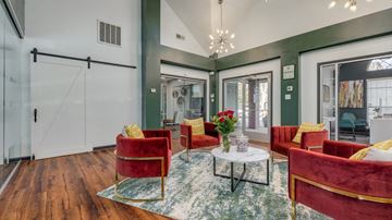 Raleigh apartment for rent - A living room with red chairs and a glass table.