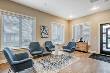Kansas City apartment for rent - A living room with grey chairs and a white table.