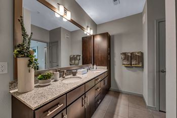 A bathroom with granite counter tops and a large mirror