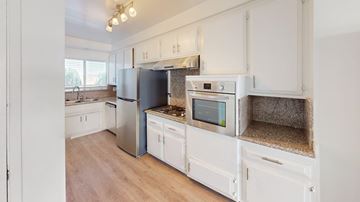 Los Angeles apartment for rent - A kitchen with white cabinets and a stainless steel refrigerator.