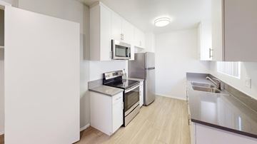 Granada Hills apartment for rent - A kitchen with white cabinets and appliances.