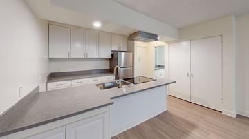 Los Angeles apartment for rent - A kitchen with white cabinets and a grey countertop.