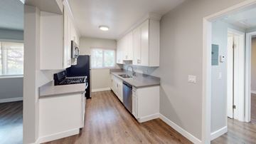 Inglewood apartment for rent - A kitchen with white cabinets and a black fridge.