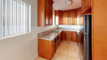 North Hollywood apartment for rent - A kitchen with wooden cabinets and a tiled floor.