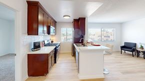 Van Nuys apartment for rent - A kitchen with white countertops and wooden cabinets.