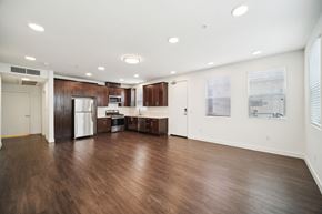 Ventura apartment for rent - A spacious kitchen with dark wood floors and white walls.