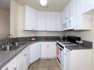 North Hollywood apartment for rent - a kitchen with white cabinets and a sink and a stove