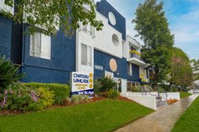 Van Nuys apartment for rent - a blue and white building with a yellow and white sign in front of it