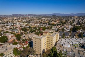 Los Angeles apartment for rent - A cityscape with a large building in the center and a mountain range in the distance.