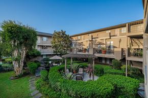 La Mesa apartment for rent - A courtyard with a tree, a bench, and a table surrounded by buildings.