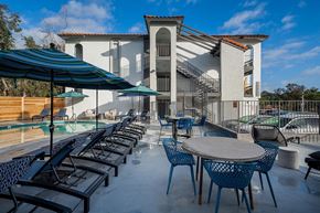 La Mesa apartment for rent - A patio with tables and chairs and a building in the background.