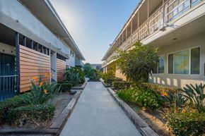 Inglewood apartment for rent - A sunny day in a residential area with a pathway and plants on either side.