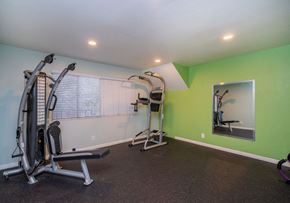 Inglewood apartment for rent - A home gym with a green wall and a mirror.