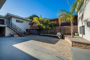 Inglewood apartment for rent - A concrete patio area with a black tarp and a wooden fence.