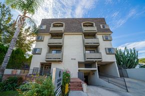 North Hollywood apartment for rent - an apartment building with many balconies and a palm tree