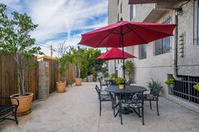 North Hollywood apartment for rent - A patio with a table and chairs under a red umbrella.