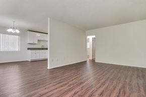 Granada Hills apartment for rent - an empty living room with a kitchen in the background