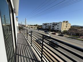 North Hollywood apartment for rent - A view from a balcony looking out at a street with cars and buildings.