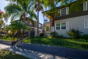 Los Angeles apartment for rent - a street view of two apartment buildings with palm trees in front of them