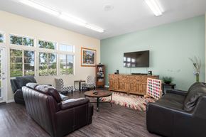 Chatsworth apartment for rent - A living room with a brown leather couch, a wooden cabinet, and a flat screen TV.