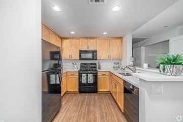 Encino apartment for rent - A kitchen with wooden cabinets and black appliances.