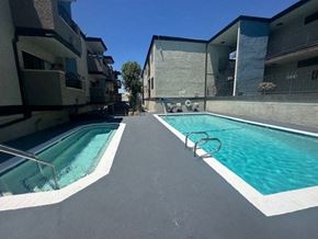 Van Nuys apartment for rent - a swimming pool is next to an apartment building