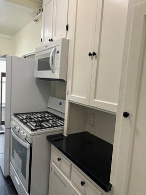 Los Angeles apartment for rent - a small kitchen with white cabinets and a stove and microwave