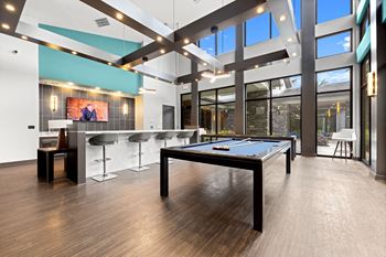 A game room with a pool table and a bar