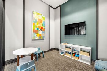 A room with a table and chairs and a television