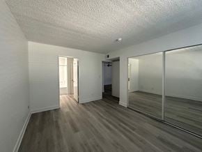 Van Nuys apartment for rent - an empty living room with a large mirror and wooden floors