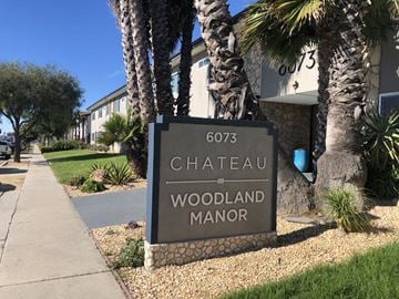 Ventura apartment for rent - A sign for Chateau Woodland Manor is displayed in front of a building.