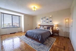 Washington apartment for rent - Bedroom with wood floors and blue area rug at 4000 Massachusetts Avenue Apartments, Washington, District of Columbia