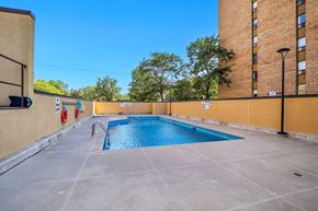 Ottawa apartment for rent - A small pool surrounded by a concrete floor and a building.