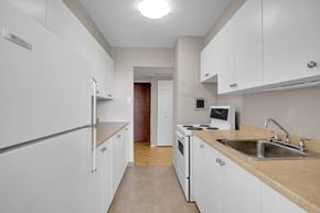Ottawa apartment for rent - A kitchen with white cabinets and a refrigerator.