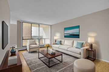 Ottawa apartment for rent - A living room with a white couch, a coffee table, and a painting on the wall.