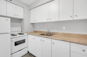 Ottawa apartment for rent - A kitchen with white cabinets and a wooden countertop.