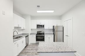Stonecrest apartment for rent - A kitchen with white cabinets and a granite countertop.